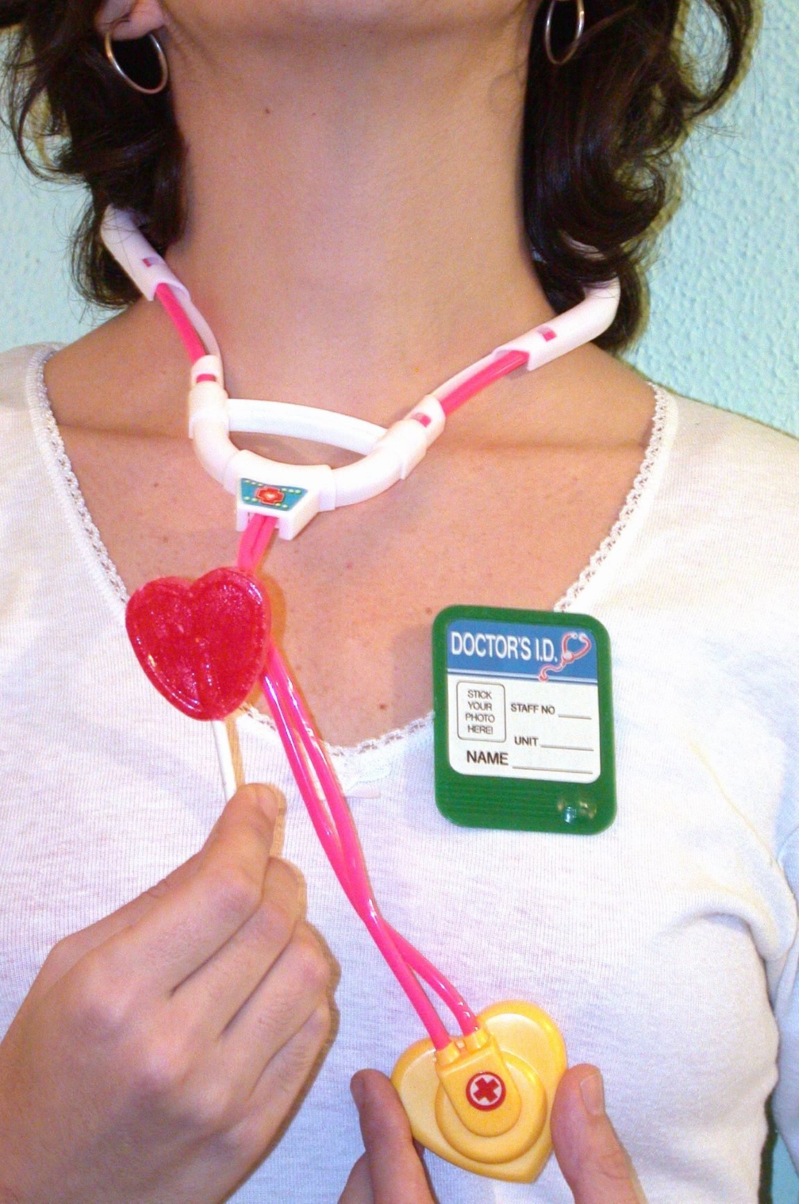 Pediatra con fonendoscopio de juguete y piruleta de corazón