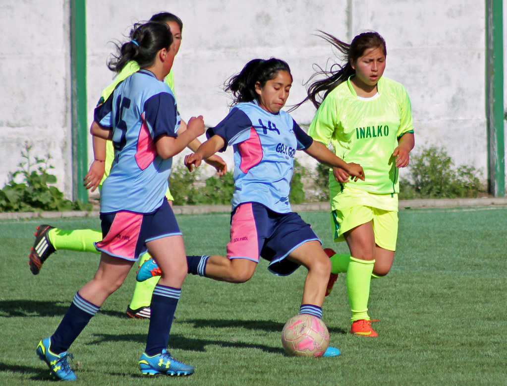 Cuatro chicas jugando al fútbol.