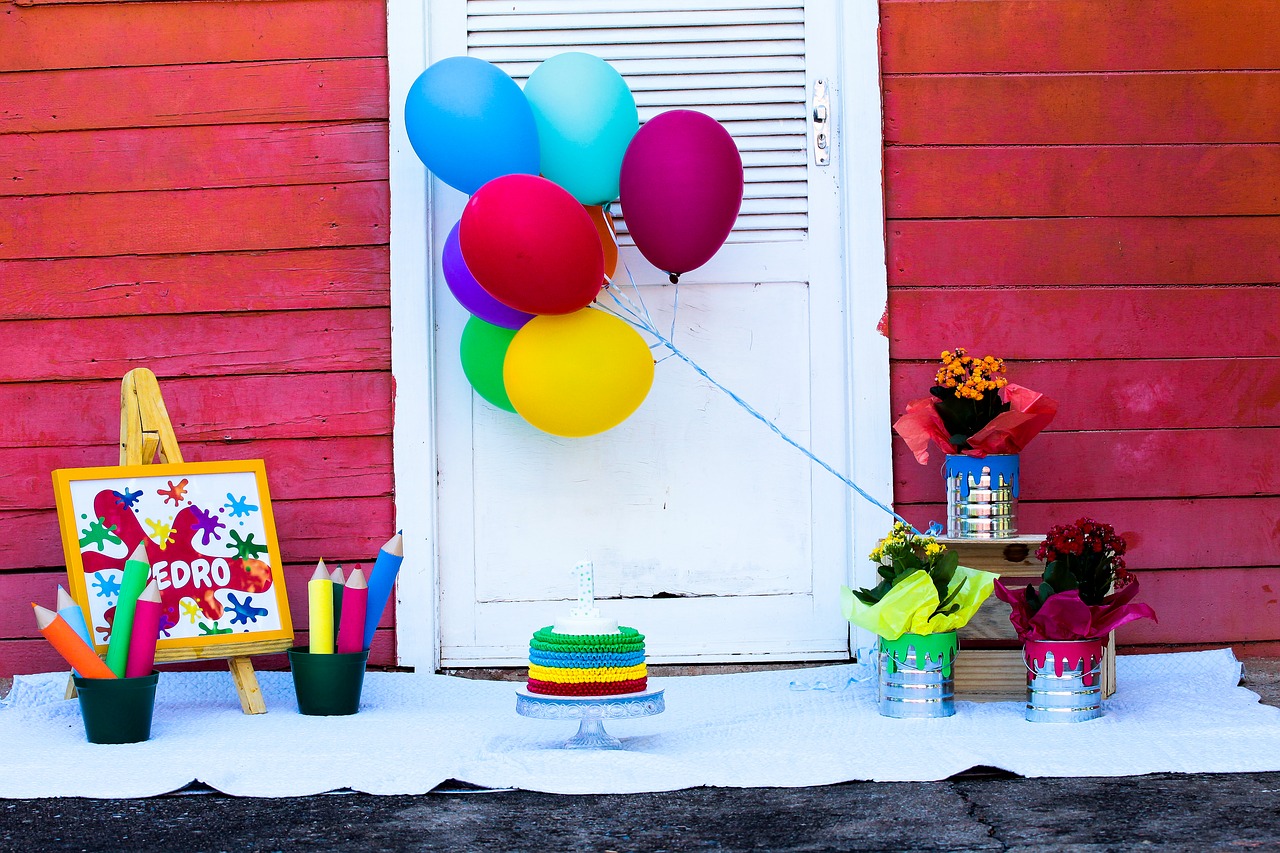 Al lado de una puerta blanca mucho colorido con globos y pinturas