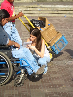 Mujer entrevistando a persona en silla de ruedas.